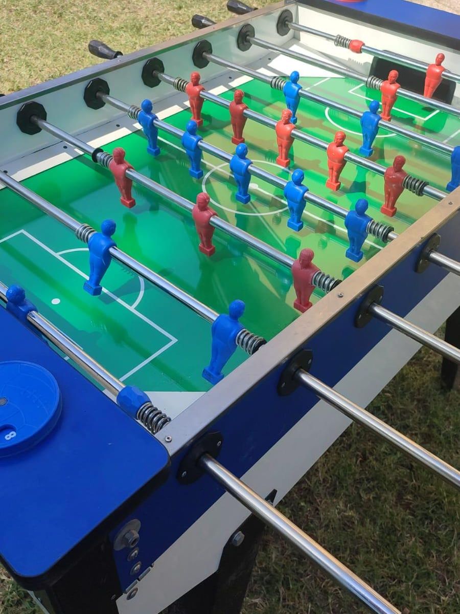 Calcio balilla con omini rossi e blu, installato all'aperto sul prato