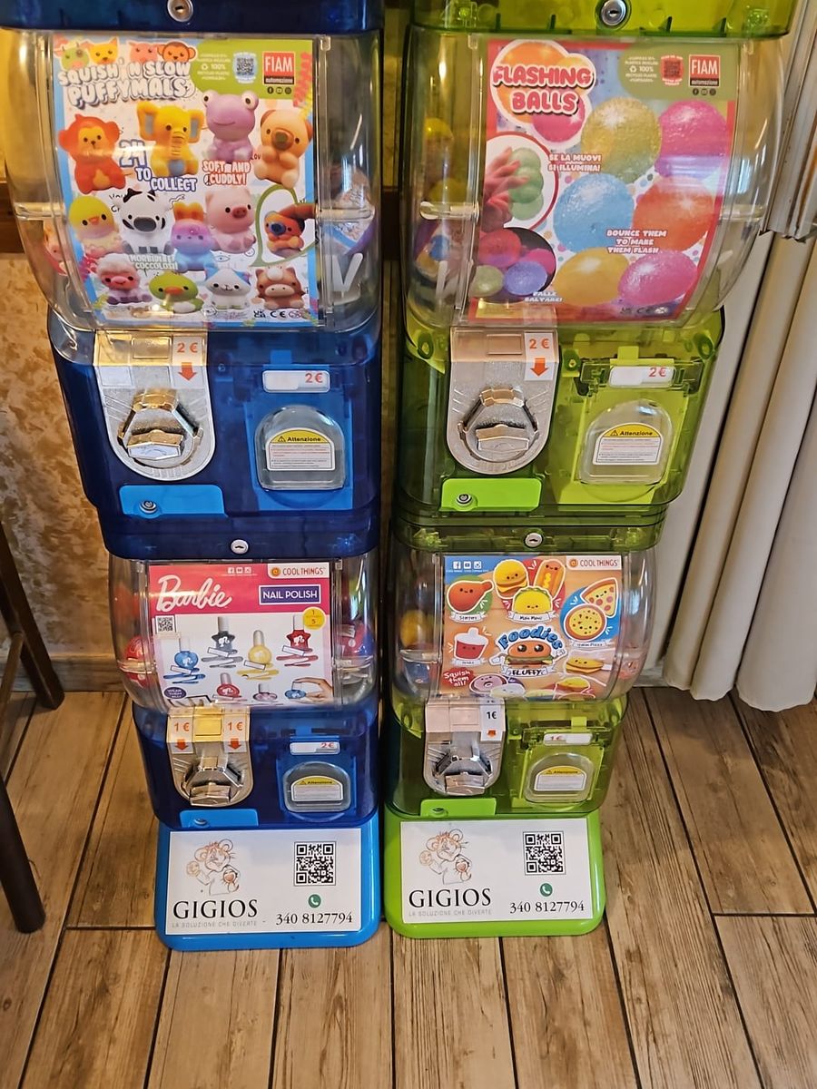 Due colonne di distributori di palline e gadget con l'etichetta Gigios, su un pavimento in legno