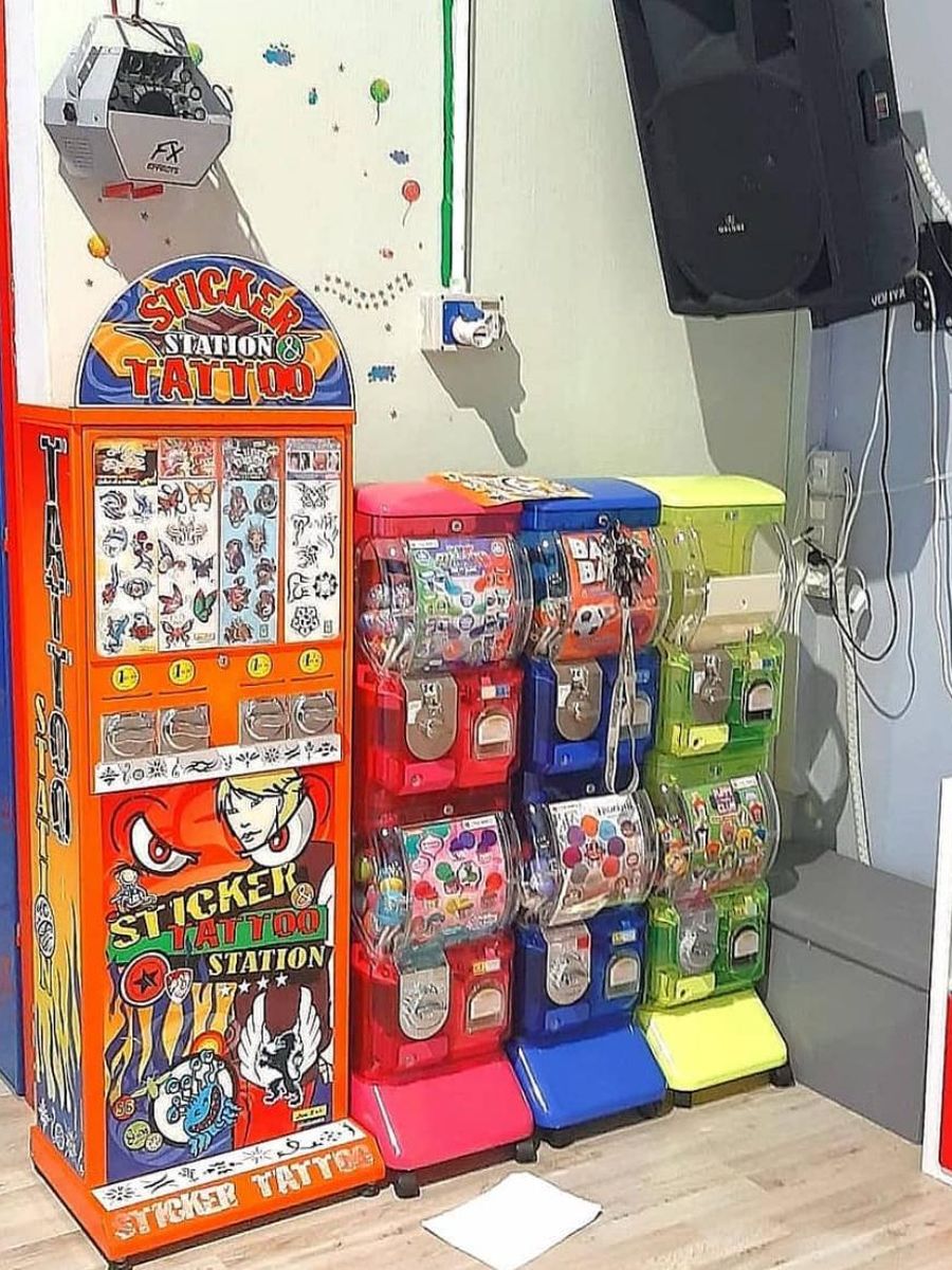 Distributore di tatuaggi e sticker accanto a distributori di palline colorati