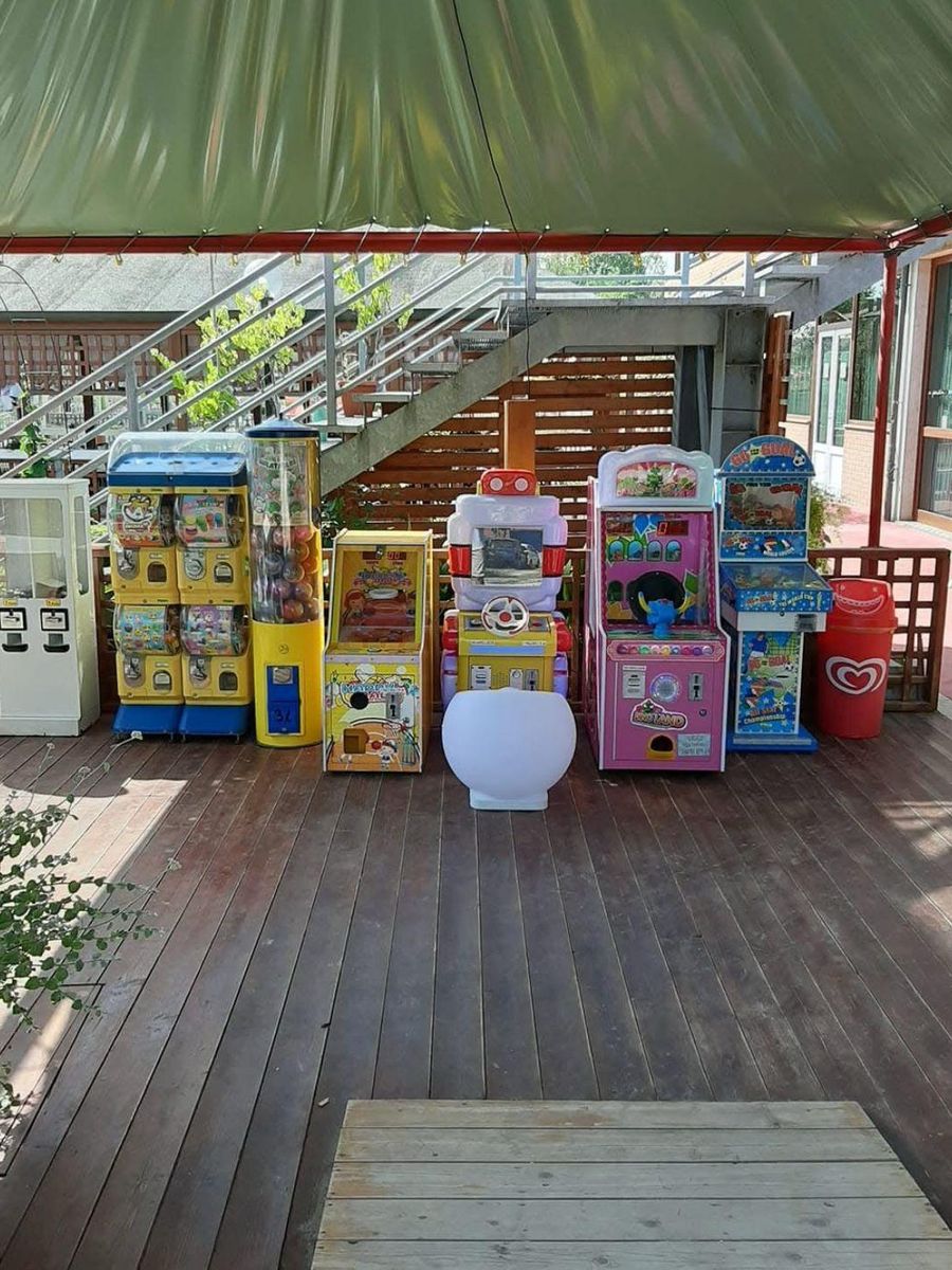 Terrazza coperta di un locale con una fila di giochi elettronici e distributori